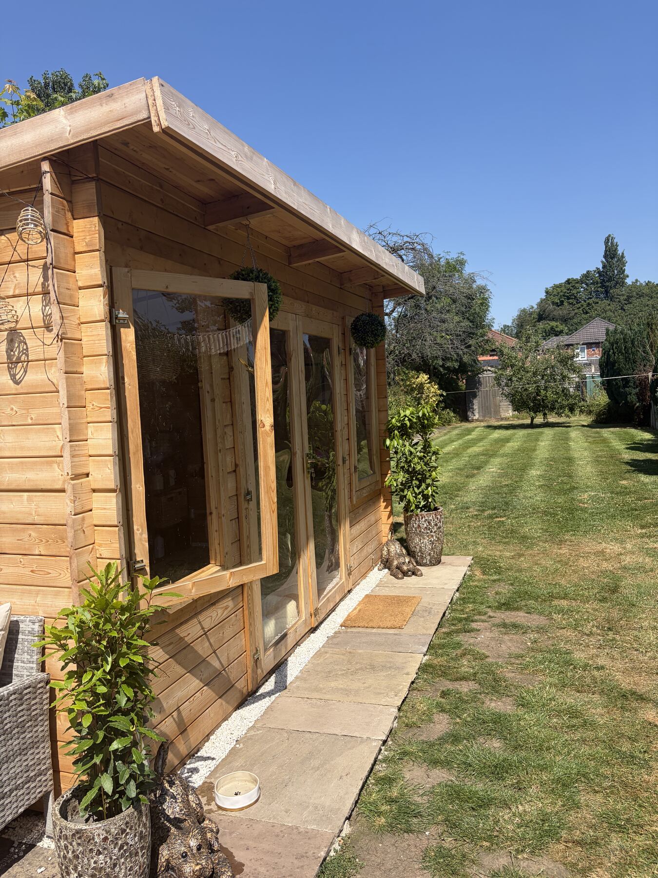 Four Paws & Co's wooden garden grooming studio in Cheadle Hulme on a sunny day